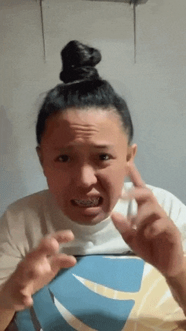 a woman with braces on her teeth is making a funny face with her hands
