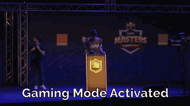 a man stands at a podium in front of a banner that says gaming masters