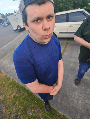 a young man wearing a blue shirt with the word aura on the back