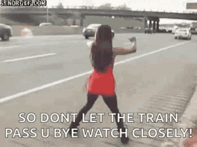 a woman in a red dress is standing on the side of a highway and says so dont let the train pass