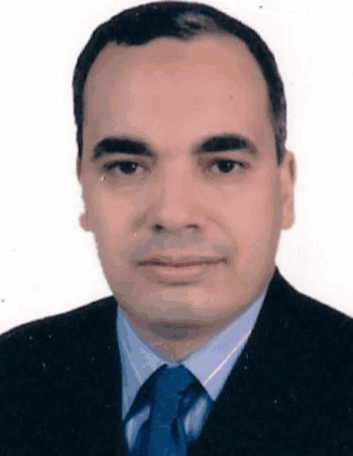 a man is wearing a suit and tie and looking at the camera