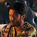 a man with a beard is wearing a floral shirt and tie .