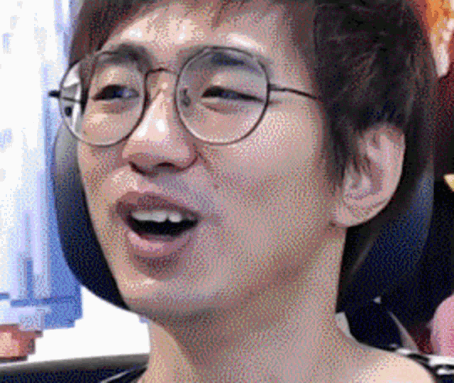 a man wearing glasses is making a funny face .