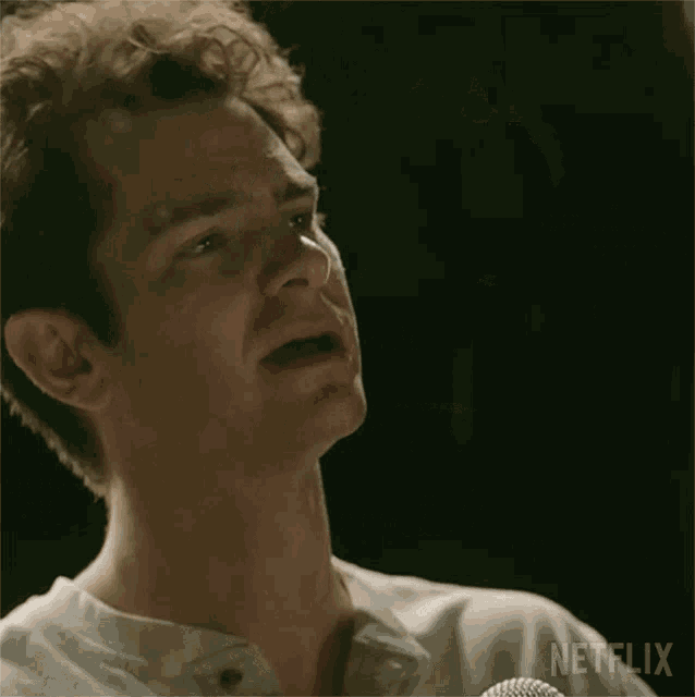 a man is singing into a microphone in a dark room .