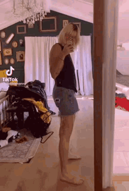 a woman is taking a picture of herself in front of a mirror .