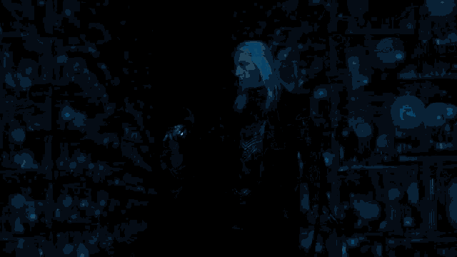 a group of people standing in a dark room holding glowing wands