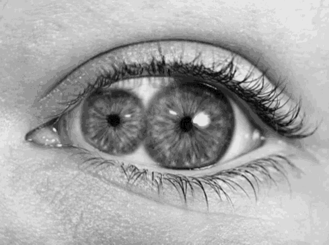 a black and white photo of a woman 's eye