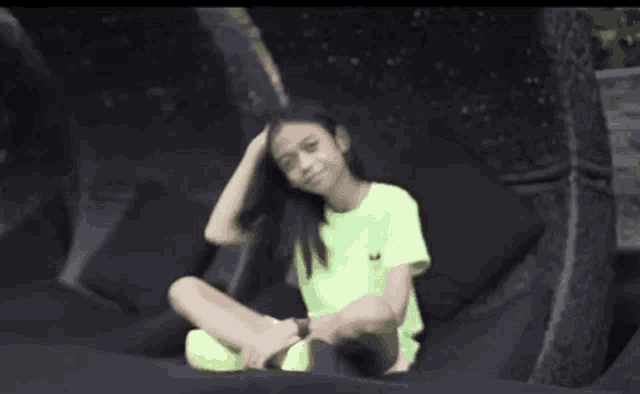 a young girl is sitting on a black chair with her legs crossed .