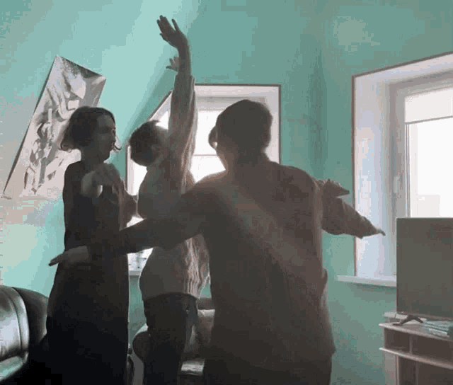 a group of people are dancing in a room with a poster on the wall that says ' i love you '