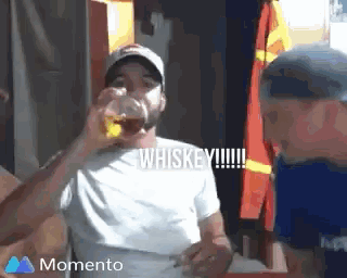 a man drinking a glass of whiskey with the words whiskey written on the screen