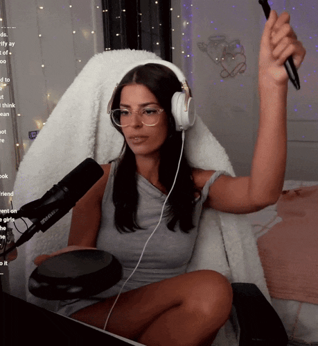 a woman wearing headphones and glasses is sitting in front of a microphone