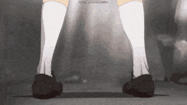 a person wearing white socks and black shoes is walking