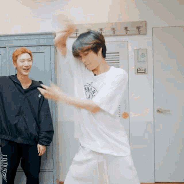 a man in a white shirt with the word skate on it is dancing