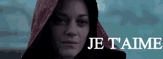 a woman is wearing a red hood and the words je t'aime are on the bottom of the image .