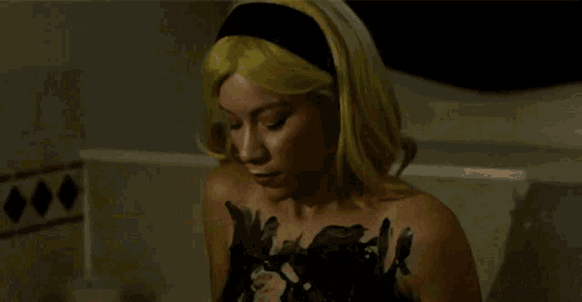 a woman with yellow hair and a black dress on
