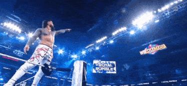 a wrestler in a ring with a sign that says royal rumble in the background