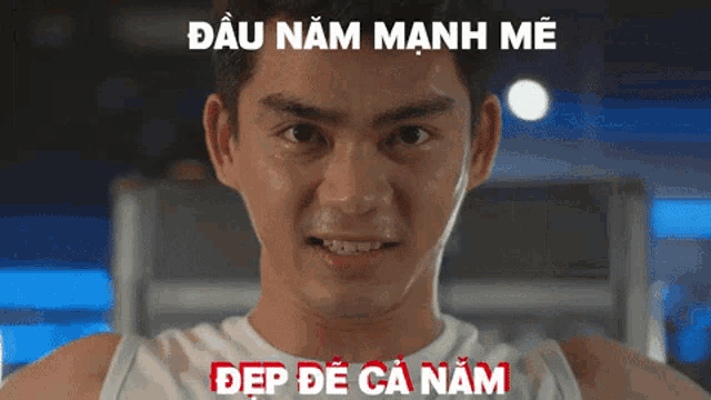 a man in a white tank top is looking at the camera with a foreign language caption above him