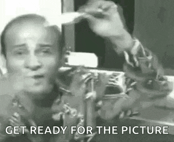 a black and white photo of a man taking a picture of himself with a camera .