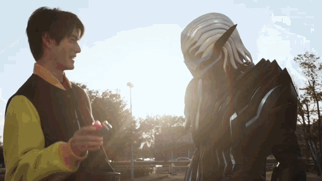 a man in a yellow jacket is talking to a man in a black and white costume