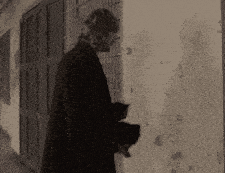 a woman in a black coat is standing next to a wall