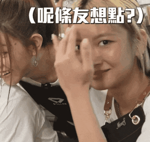 a woman covering her face with her hand while another woman watches