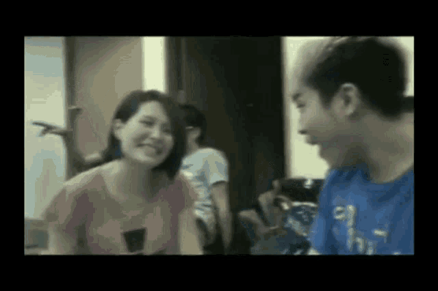 a man and a woman are talking to each other in a room