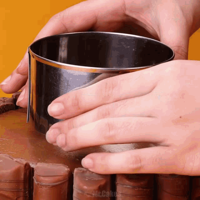 a close up of a person cutting a cake with the words mr.cakes on the bottom right