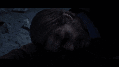 a man with a beard is laying on the ground with his eyes closed