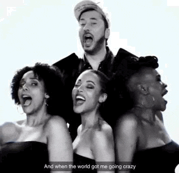 a group of women are standing next to each other singing a song in a black and white photo .