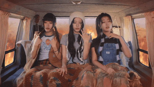 three girls are sitting in the back of a van