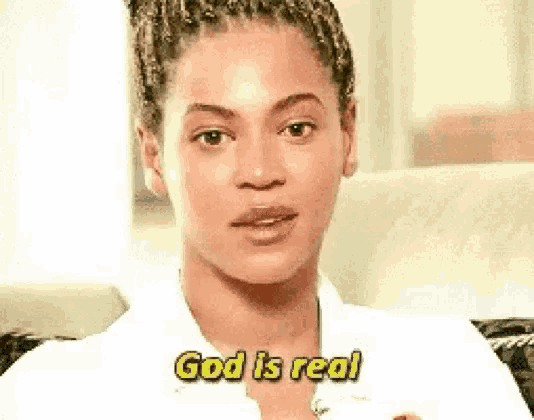 a woman in a white shirt is sitting on a couch and says `` god is real '' .