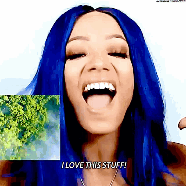 a woman with blue hair is smiling and saying i love this stuff