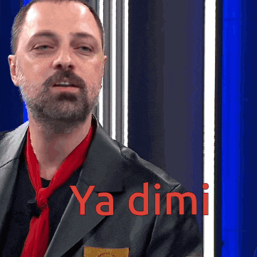 a man with a beard wearing a black jacket and a red scarf with ya dimi written on it