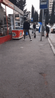 people walking down a sidewalk in front of a store that says subway on it