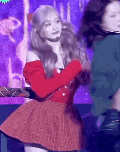 a woman in a red dress is dancing on stage .