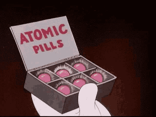 a person is holding a box of atomic pills in their hand