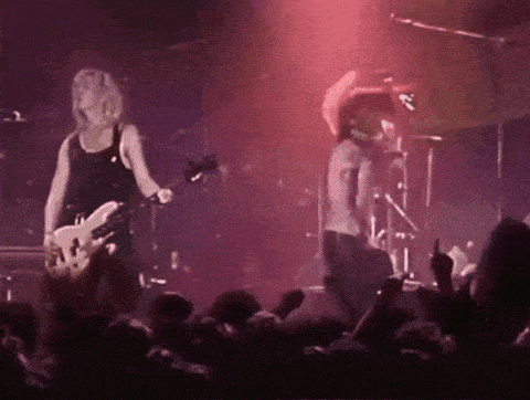 a man playing a guitar on stage with a crowd watching