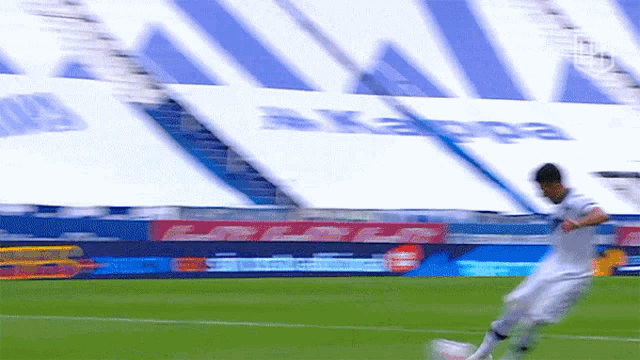 a blurry picture of a soccer player kicking a ball in front of a kappa sign