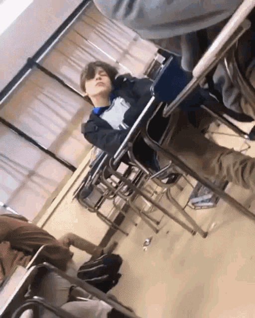 a boy sitting at a desk in a classroom