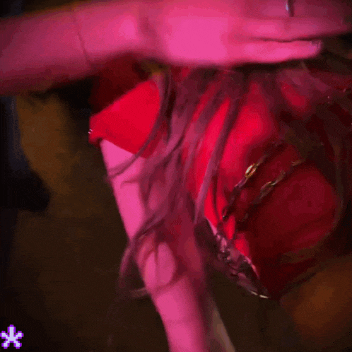 a woman in a red dress has a tattoo on her arm with a star on it