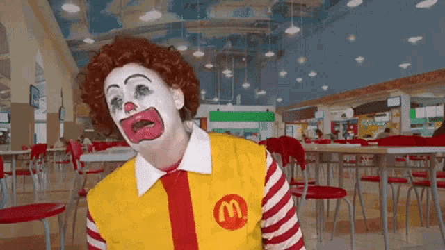 a clown in a mcdonald 's uniform with a m on his vest