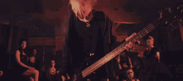 a man playing a guitar in front of a crowd