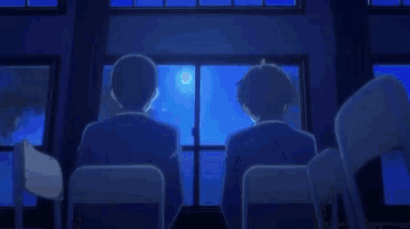 a blurry picture of a person in a dark room with a blue light behind them