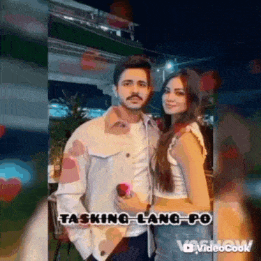 a man and a woman are standing next to each other in a video .