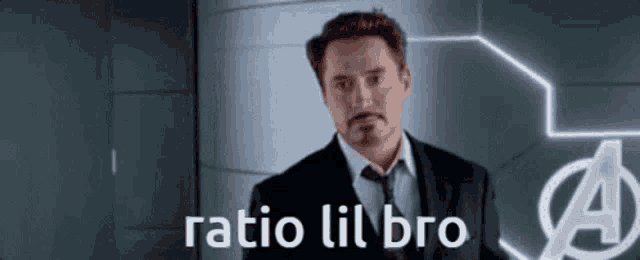 a man in a suit and tie is standing in front of a wall with the words `` ratio lil bro '' .