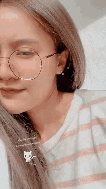 a close up of a woman wearing glasses and a striped shirt with a cat on it