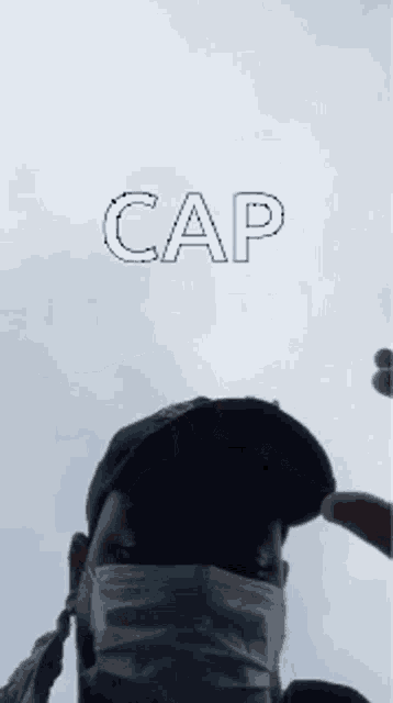a person wearing a mask is holding a hat with the word cap written on it