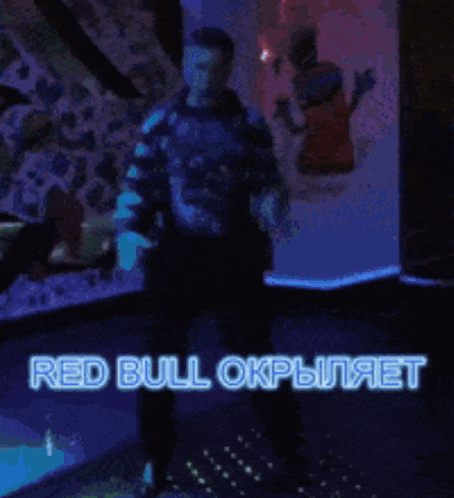 a man is dancing in a dark room with the words red bull written in blue