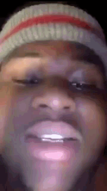 a close up of a person 's face wearing a beanie