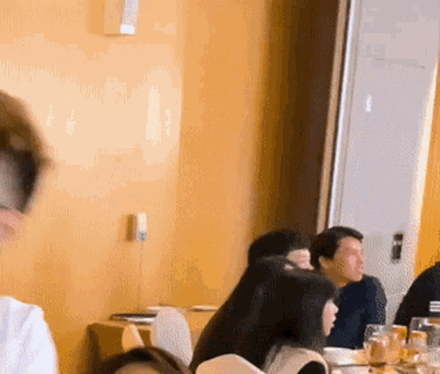 a group of people sitting at tables in a restaurant